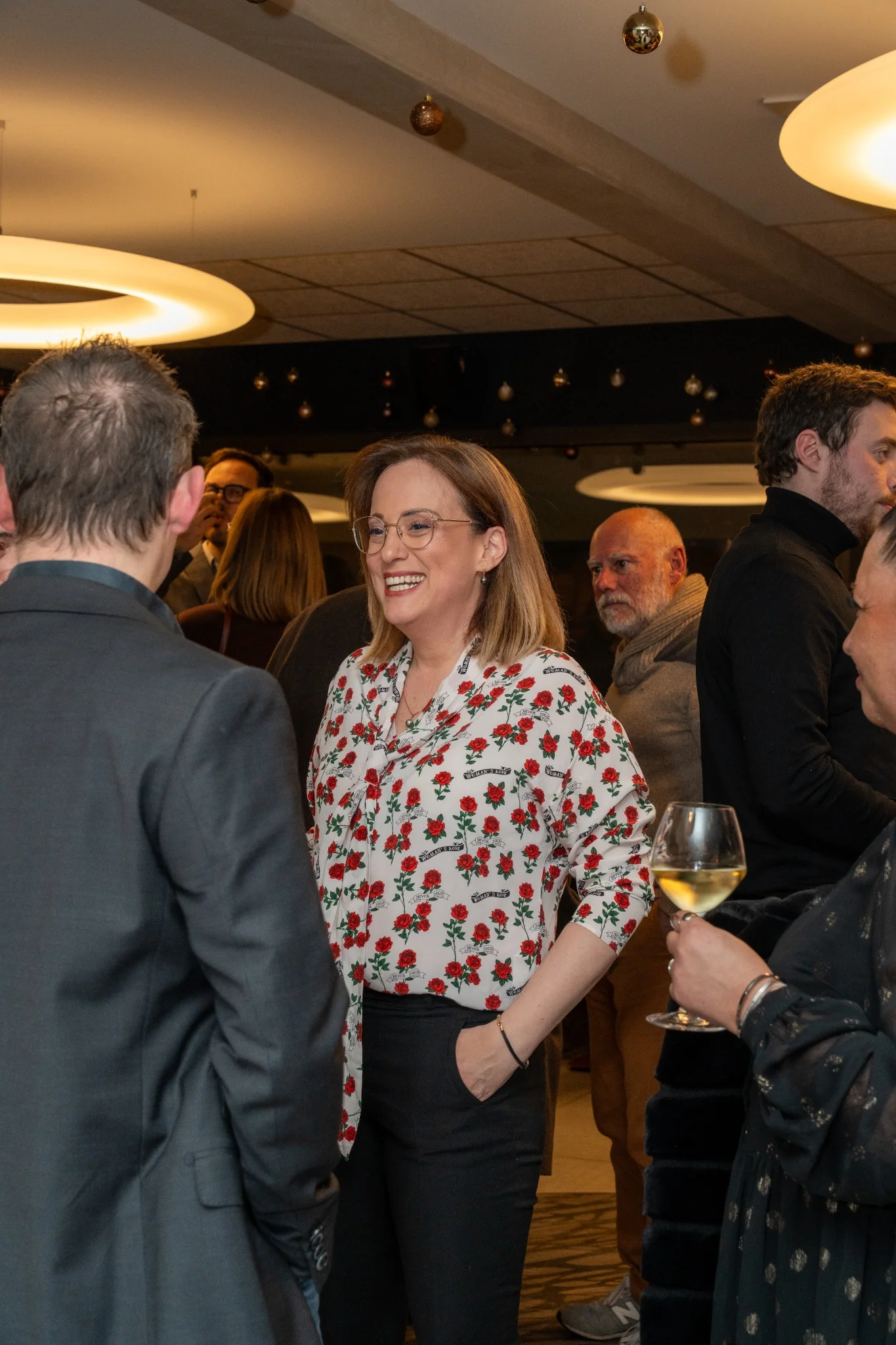 Des invités échangent et sourient pendant la soirée