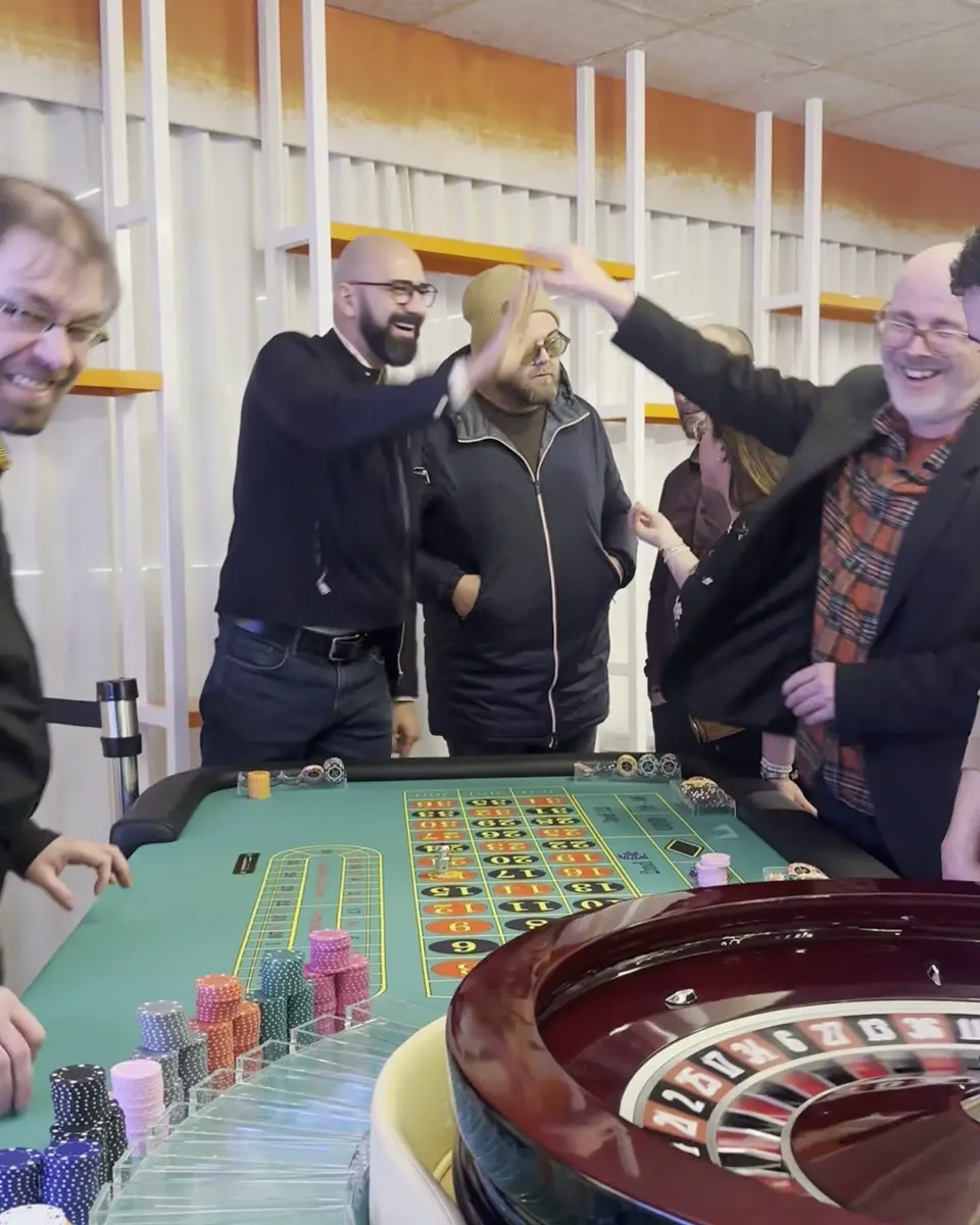 Des invités souriants échangent un high five autour de la roulette