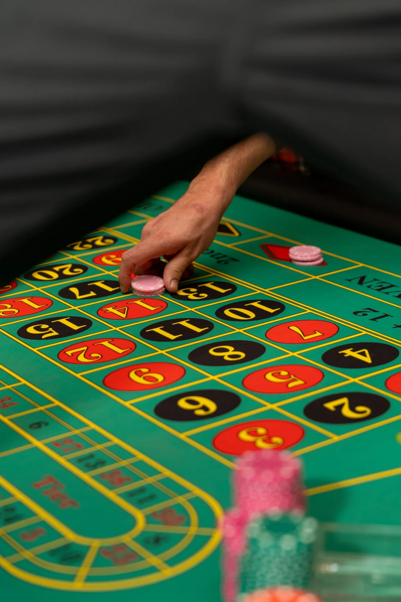 Une main pose un jeton sur la table de roulette